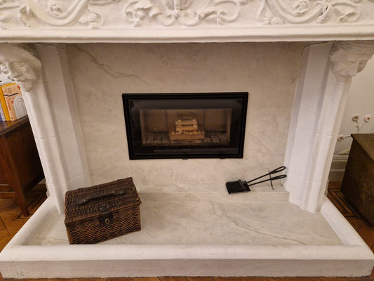 Carved stone fireplace with marble slips and hearth, fabricated and installed by Geology Ltd